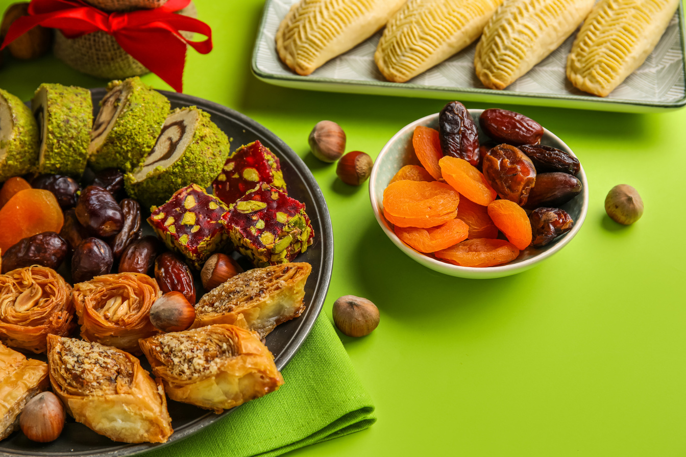 Plates with Treats on Green Background, Closeup. Novruz Bayram Celebration